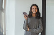 © Maria Vitkovska - Portrait of beautiful smiling businesswoman wearing casual wear, holding phone