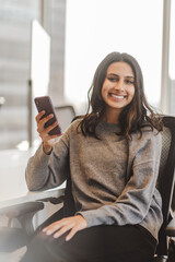 Wall Mural - Confident stylish indian business woman wearing casual clothes smiling and looking at camera