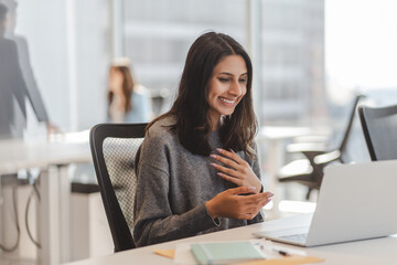 Smiling indian business woman having laptop video call, working online