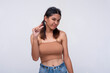 © Mdv Edwards - A young asian woman expressing something tiny or little with her thumb and index finger, looking unimpressed or condescending. Describing a small package. Isolated on a white background.