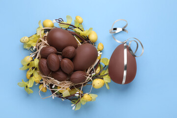 Wall Mural - Delicious chocolate eggs on light blue background, flat lay