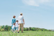 © buritora - 春・夏に公園・草原を歩く家族・ファミリーの後ろ姿（子供・両親・移住・田舎暮らし）