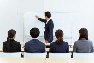 会議室・教室で研修・塾・講義・講習・セミナーを受けるビジネスマン・ビジネスウーマンの後ろ姿

