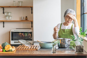 Poster - 家のキッチンで料理を作るアジア人のシニア・高齢者女性（認知症・悩む）
