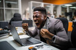 Frustrated Black Man Sitting at Desk in the Office, Expressing Irritation and Anger Over Workplace Stress
