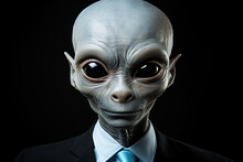 Portrait Of A Gray Extraterrestrial With Large Eyes Wearing Formal Attire. Isolated On A Black Background