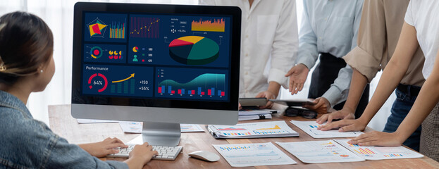 Fototapete - Panorama shot analyst team utilizing BI Fintech to analyze financial report with laptop. Businesspeople analyzing BI power dashboard displayed on laptop screen for business insight. Scrutinize
