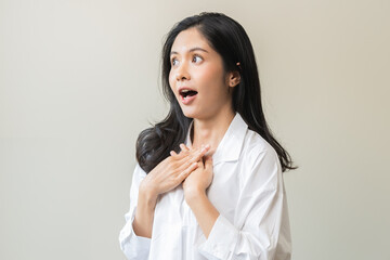 Wall Mural - Smile positive, feeling amazed asian young woman wearing casual shirt, portrait of pretty female with black long hair, standing expression gesture face surprised looking at camera on white background.