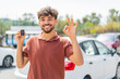 © luismolinero - Young Arabian handsome man holding car key at outdoors showing ok sign with fingers