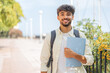 © luismolinero - Young student Arabian man at outdoors smiling a lot