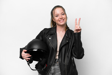 Wall Mural - Young caucasian girl with a motorcycle helmet isolated on white background smiling and showing victory sign