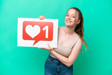 Canvas Print - Young caucasian woman isolated on green background holding a placard with Like icon with happy expression