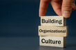 A wooden block with the words Building, Organizational, Culture, Modern approach to working with people in a team, Creative concept, copy space