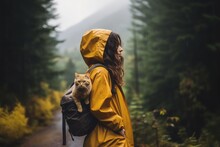Female In A Short Mustard Raincoat Traveler And Cat On Shoulder With Backpack Standing In Rain Forest. Generative AI