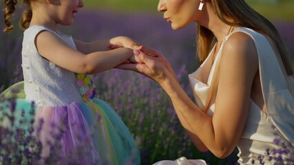 a woman kisses the small hands of her cute child