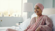 Indian cancer patient sitting on a bed, with headbands in the head, waiting to go to the operation room