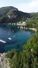 Canvas Print - Vertical drone view over an azure seacoast with forested cliffs in Corfu, Greece