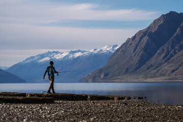 Wall Mural - New Zealand mountain and lake landscape with person fishing