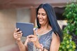 © Krakenimages.com - Middle age hispanic woman smiling confident using touchpad at street