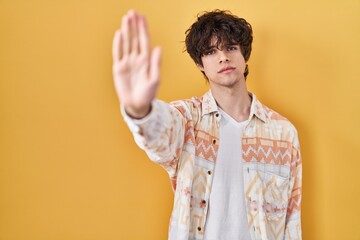 Canvas Print - Young man wearing casual summer shirt doing stop sing with palm of the hand. warning expression with negative and serious gesture on the face.