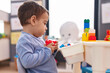 © Krakenimages.com - Adorable hispanic boy playing with construction blocks sitting on table at kindergarten