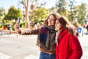 Sticker - Two women mother and daughter make selfie by smartphone at park