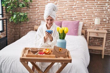 Sticker - Young blonde woman wearing bathrobe having breakfast at bedroom