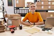 © Krakenimages.com - Young blonde woman ecommerce business worker using laptop writing on package at office