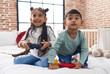 © Krakenimages.com - Adorable boy and girl playing video game sitting on sofa at bedroom