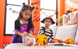 © Krakenimages.com - Adorable boy and girl having halloween party holding candies at home