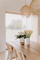 Poster - Interior shot of a contemporary styled living space with a wooden table and vases full of flowers