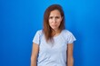 © Krakenimages.com - Brunette woman standing over blue background depressed and worry for distress, crying angry and afraid. sad expression.