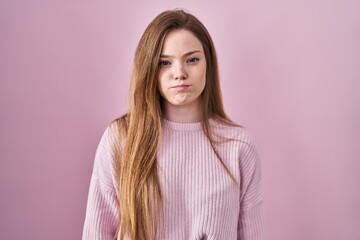 Poster - Young caucasian woman standing over pink background puffing cheeks with funny face. mouth inflated with air, crazy expression.