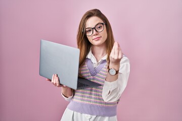 Sticker - Young caucasian woman working using computer laptop doing italian gesture with hand and fingers confident expression