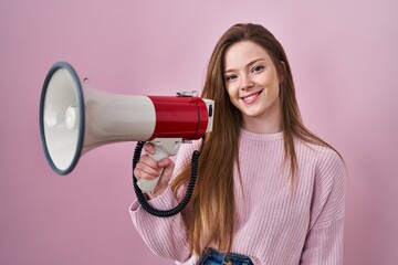 Poster - Young caucasian woman shouting through megaphone looking positive and happy standing and smiling with a confident smile showing teeth