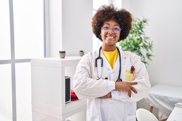 Poster - African american woman wearing doctor uniform standing with arms crossed gesture at clinic