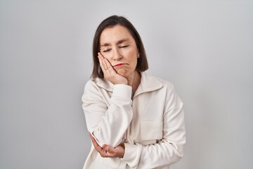 Wall Mural - Middle age hispanic woman standing over isolated background thinking looking tired and bored with depression problems with crossed arms.