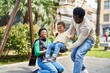 © Krakenimages.com - African american family playing on swing at playground