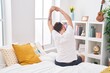 © Krakenimages.com - Young hispanic man waking up stretching arms at bedroom