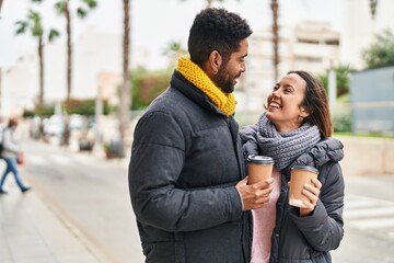 Poster - Man and woman couple smiling confident drinking coffee at street