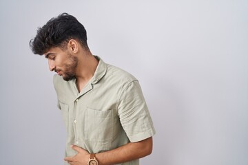 Poster - Arab man with beard standing over white background suffering of backache, touching back with hand, muscular pain