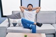 © Krakenimages.com - Young arab man relaxed with hands on head sitting on sofa at home