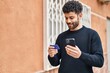 © Krakenimages.com - Young arab man using smartphone and credit card at street