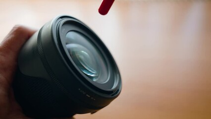 Sticker - Cleaning camera lens with a dust blower.