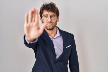 Sticker - Hispanic business man wearing glasses doing stop sing with palm of the hand. warning expression with negative and serious gesture on the face.