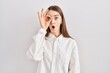 © Krakenimages.com - Young caucasian woman standing over isolated background doing ok gesture shocked with surprised face, eye looking through fingers. unbelieving expression.