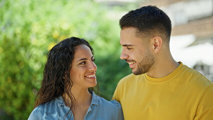 Poster - Man and woman couple smiling confident looking each other at park