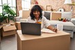 © Krakenimages.com - Young beautiful latin woman using laptop writing on notebook at new home