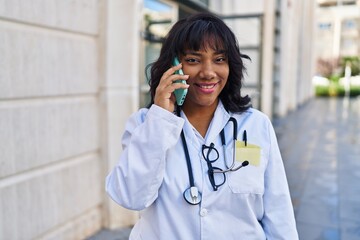 Poster - Young beautiful latin woman doctor smiling confident talking on smartphone at hospital