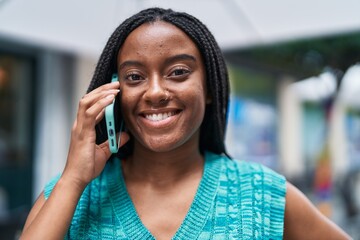 Wall Mural - African american woman smiling confident talking on the smartphone at street